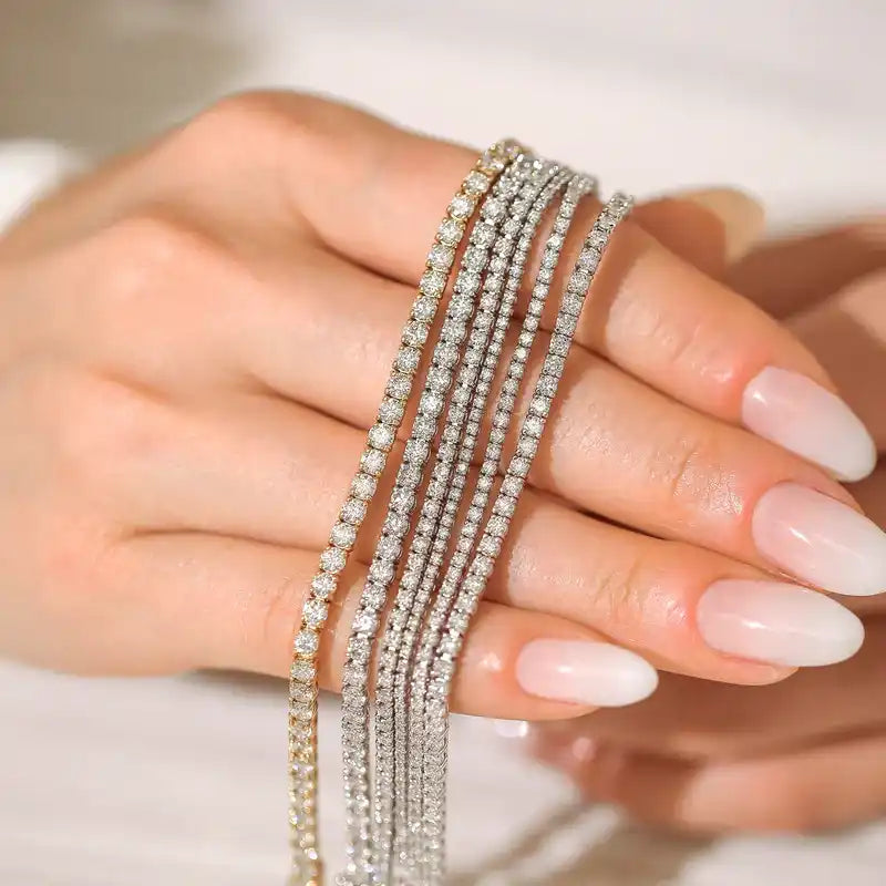 Sparkling diamond tennis bracelets draped across a manicured hand.